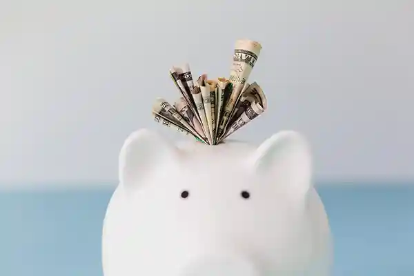 A piggy bank with money coming out of it.